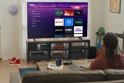 person watching Roku TV interface with Netflix Prime Video and Hulu apps in a modern living room
